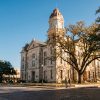 Historic limestone Comal County courthouse with a clock tower on the New Braunfels town square