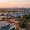 Aerial view of a fast-growing Central Texas subdivision near the Hill Country with the Austin skyline on the horizon