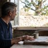 Man in a Texas Hill Country kitchen reviewing old paperwork after a former partner claims a common-law marriage